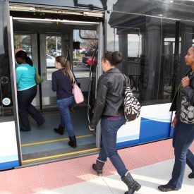 A photographic image of passengers boarding a light rail train on the HRT Tide light rail system.